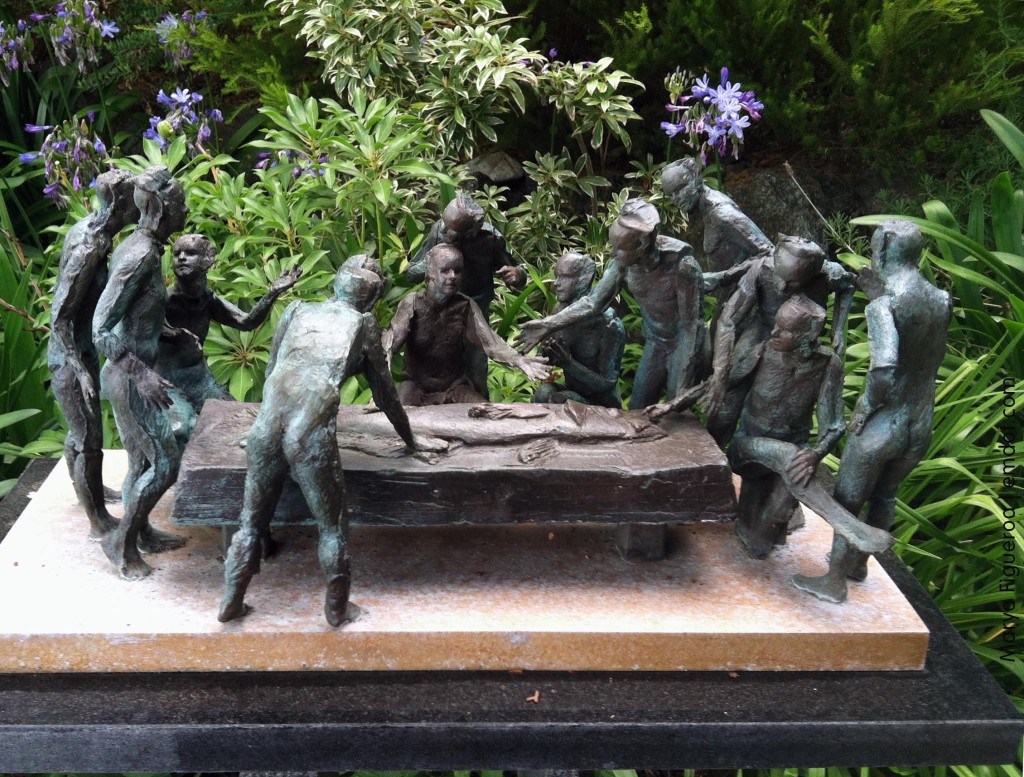 small bronze statue: men around a table