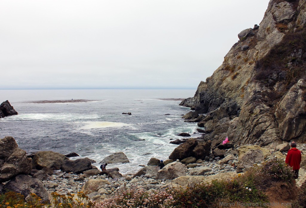 The rocky beach; woman in a pink blanket